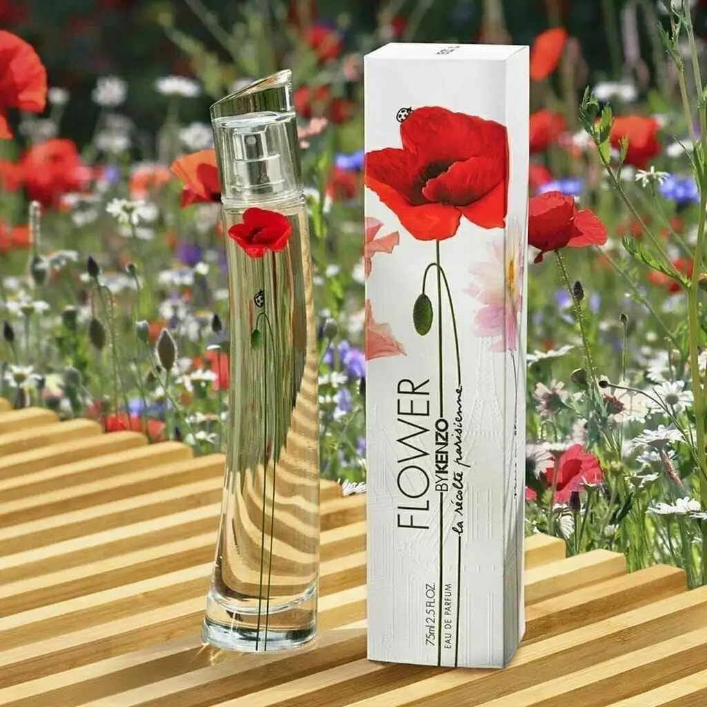 Frasco do perfume Flower by Kenzo em destaque sobre fundo claro com flores ao redor, iluminado suavemente para realçar seu design moderno e delicado.