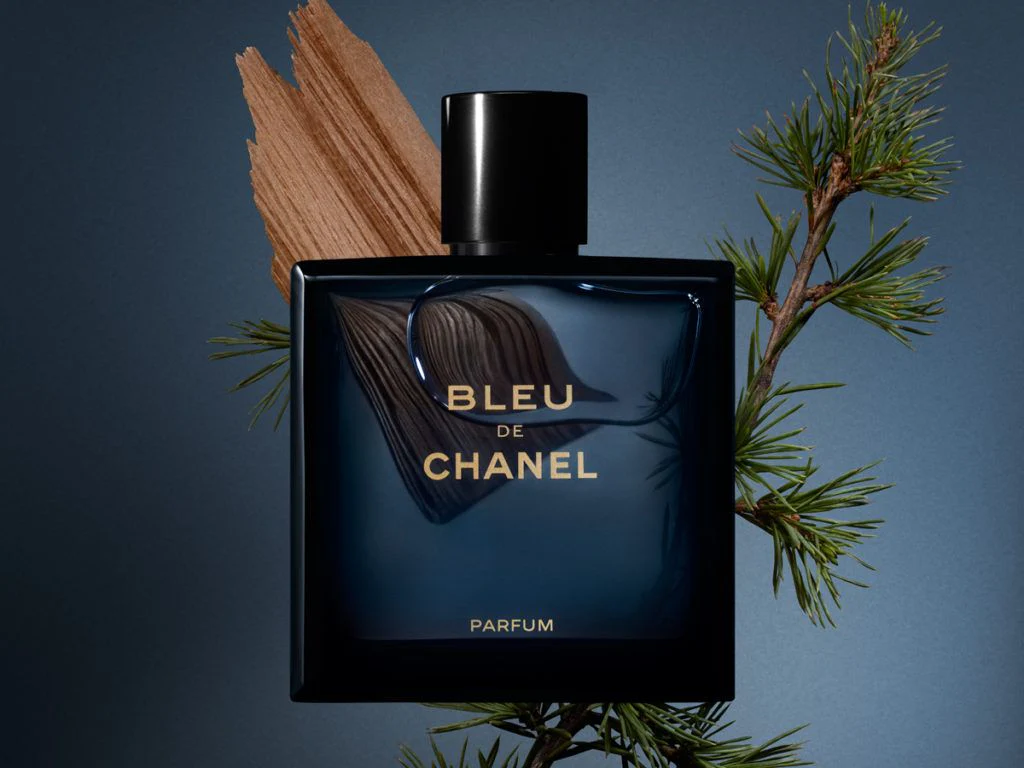 Frasco do perfume Bleu de Chanel com ingredientes naturais ao redor.