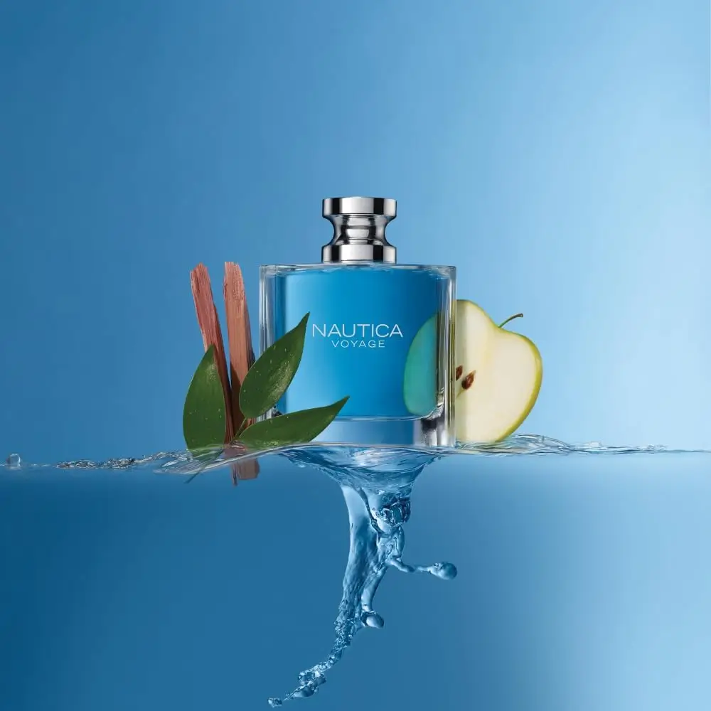 Frasco do perfume masculino Nautica Voyage sobre água azul com maçã verde, folhas e madeira, representando seu aroma aquático e frutado.