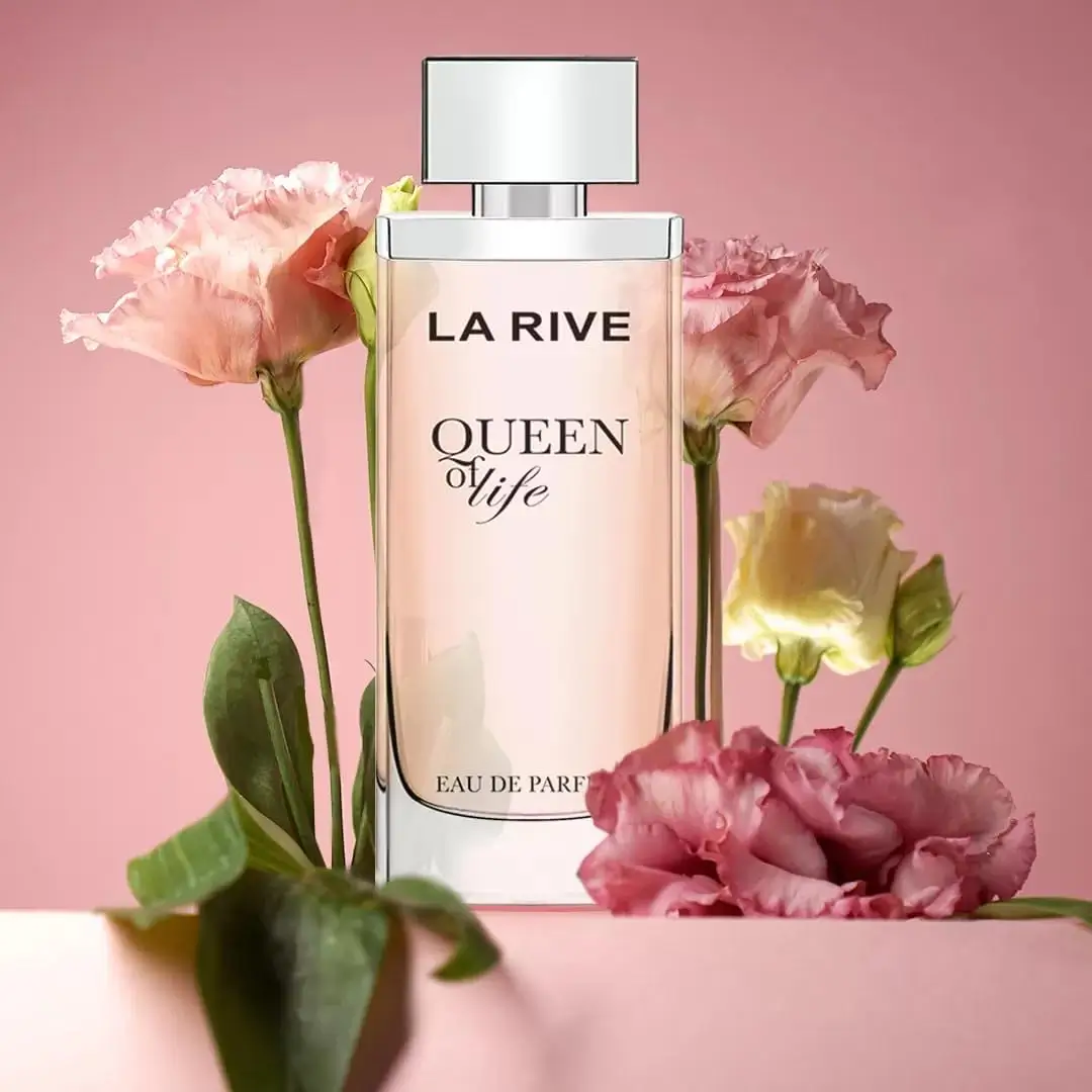 Frasco do perfume Queen of Life La Rive em cenário rosa com flores delicadas ao fundo, inspirado no estilo adocicado de La Vie Est Belle.